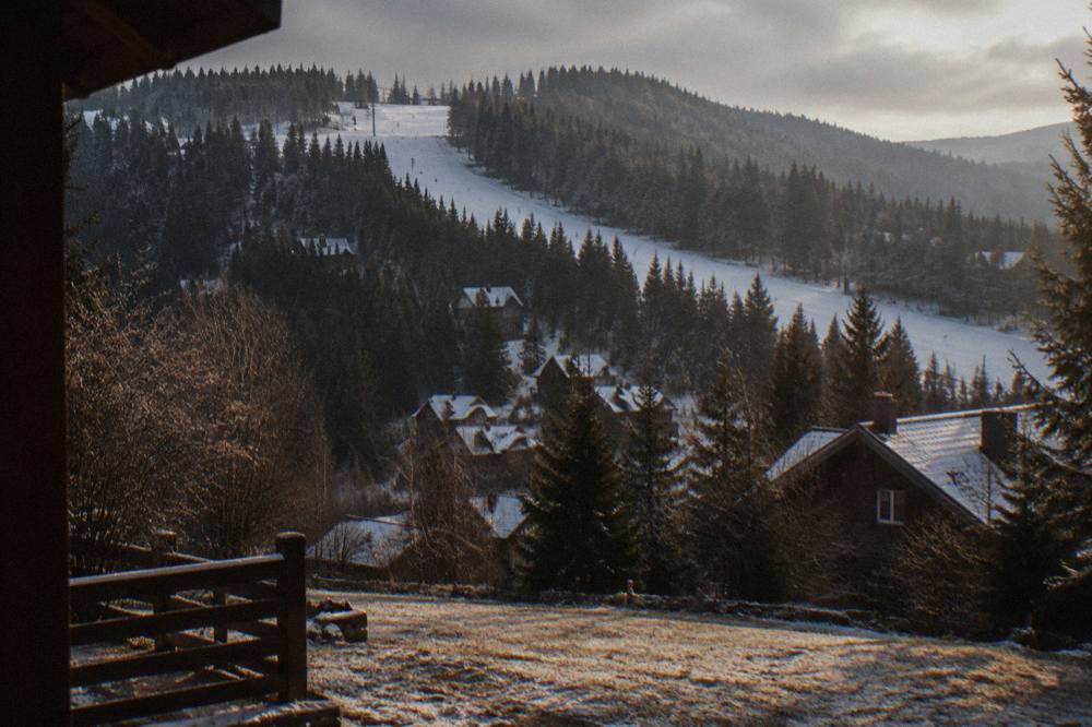 Skiers on a quiet tree-lined slope above the forest at the Păltiniș mountain resort near Sibiu