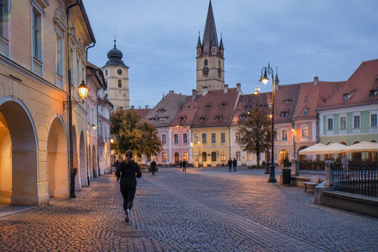 Colourful historic houses and church towers around a square in a Transylvanian old town