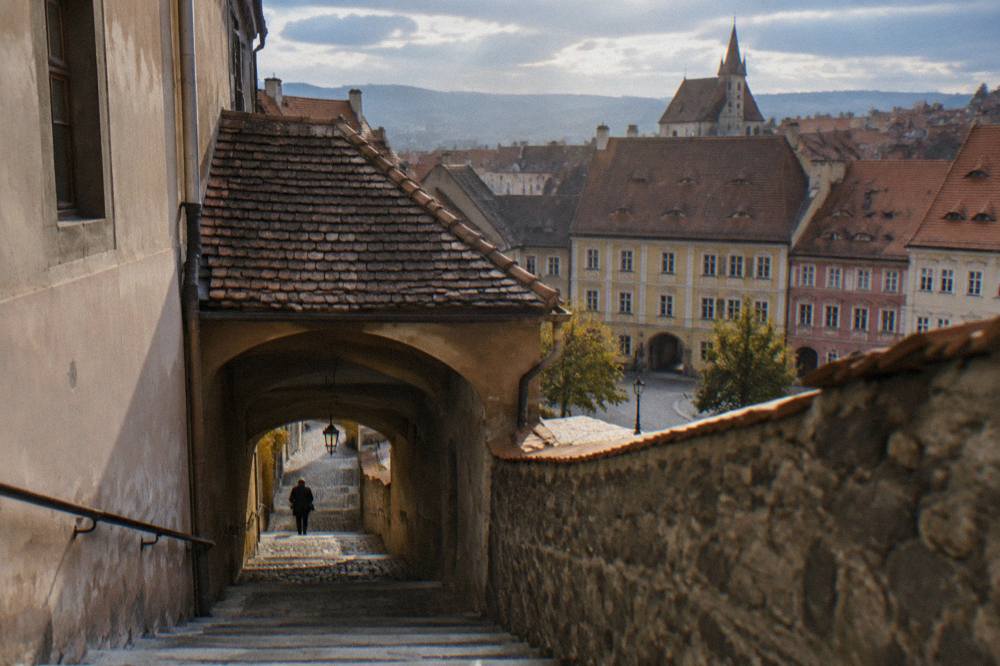 A covered stone stairway passage descending between old walls in Sibiu