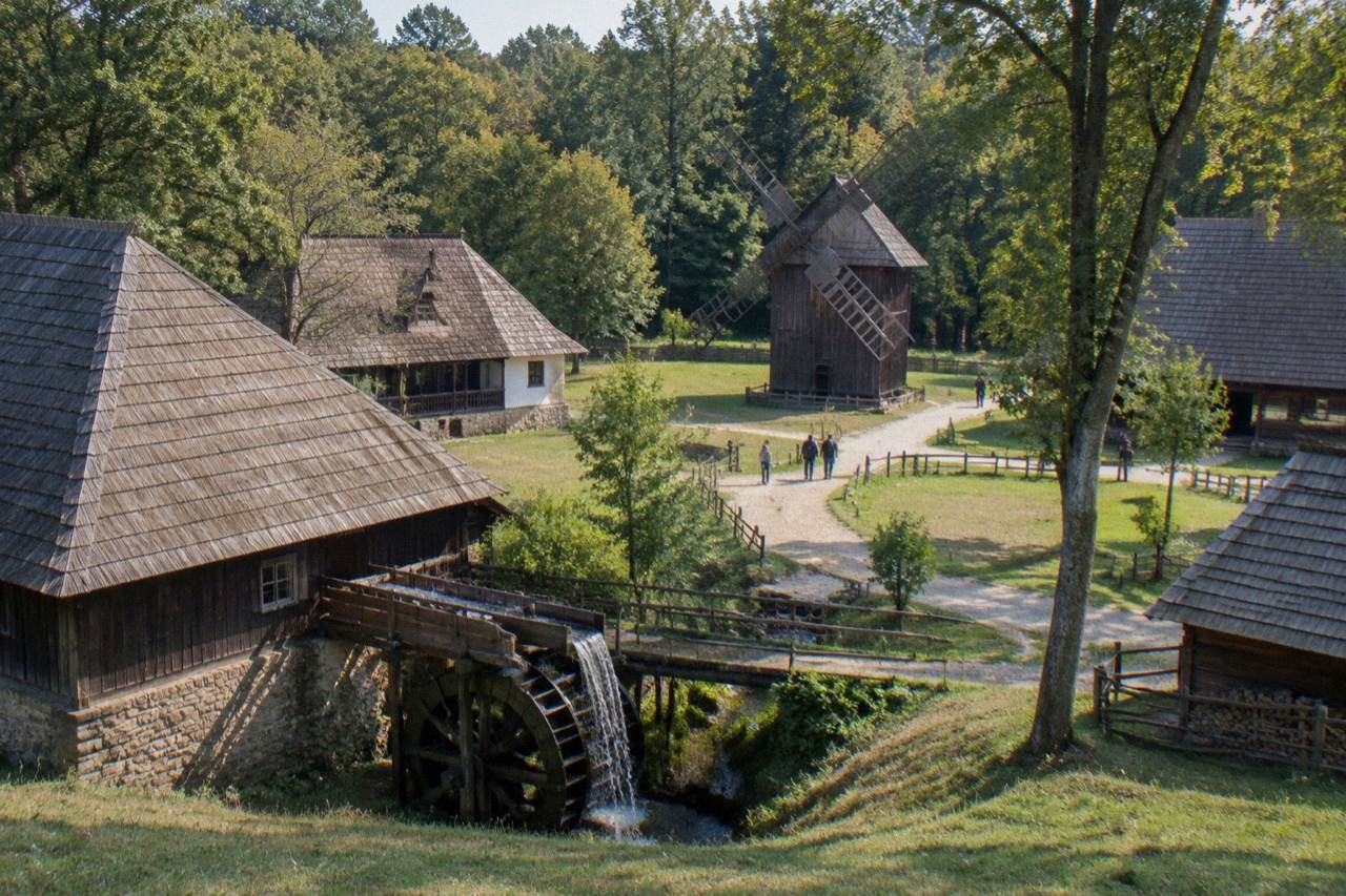 Traditional wooden farmhouses and barns of the ASTRA open-air museum among trees in Dumbrava forest near Sibiu