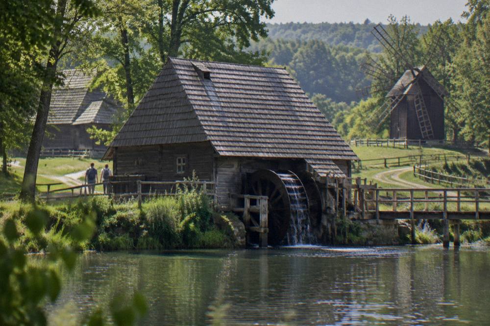 A wooden water mill beside the lake inside the ASTRA open-air museum in Sibiu