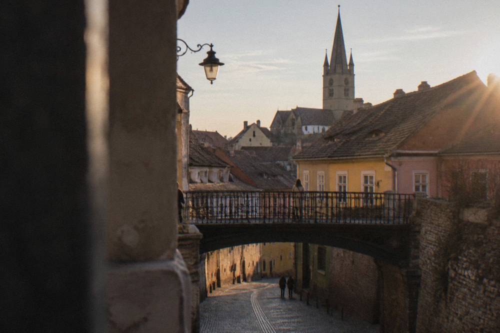 Narrow cobblestone street descending from the bridge into Sibiu's Lower Town