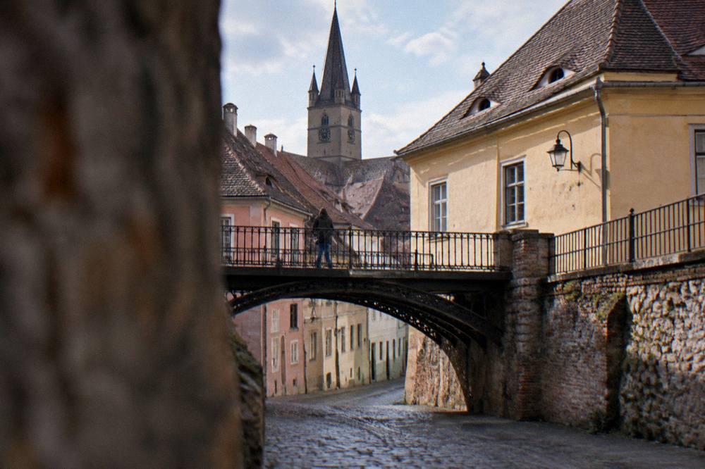 The iron Bridge of Lies seen from the cobbled lane below with morning light on the arches