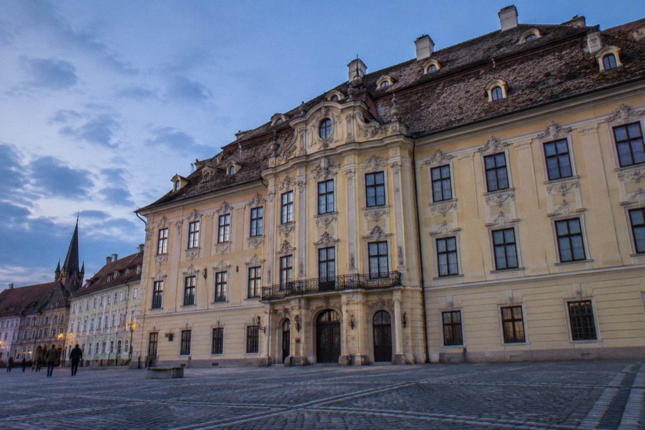 Baroque palace facade of the Brukenthal National Museum beside a grand square in Sibiu