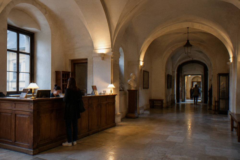 Museum ticket desk in a stone vaulted hallway with a wooden counter