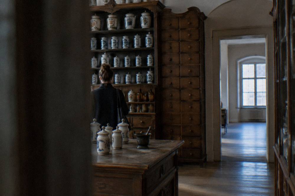 Apothecary jars and wooden drawers in a historic pharmacy museum interior