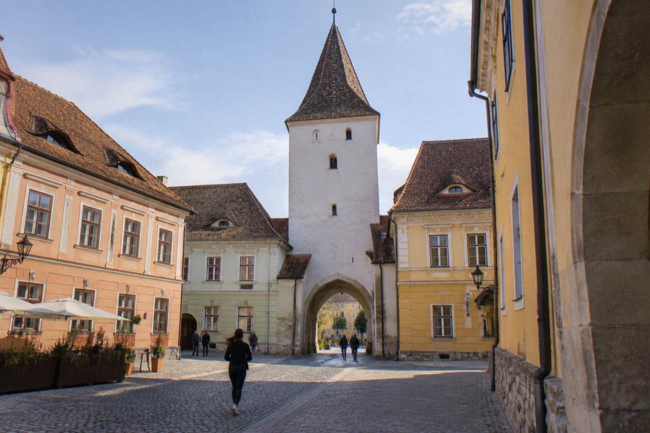 The Council Tower rising above the colourful baroque buildings of the main square in Sibiu at midday