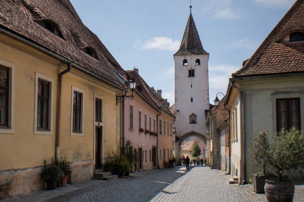A narrow cobbled street of old Saxon houses with steep roofs in a Transylvanian city