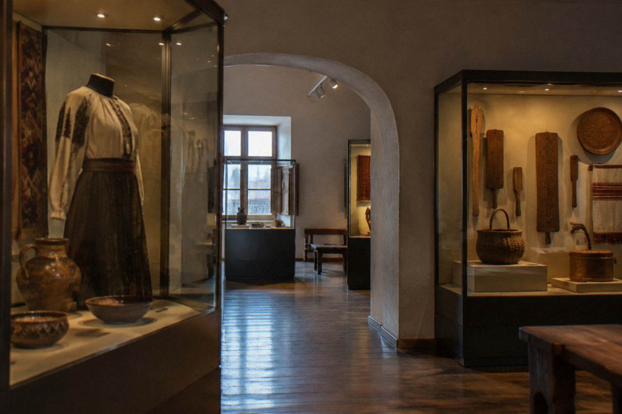 A museum gallery interior in Sibiu with display cases of traditional crafts and artefacts under soft lighting