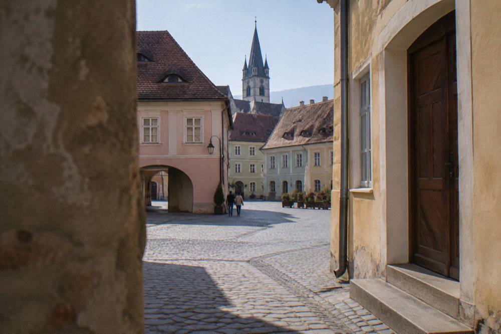 A closed wooden museum door with a notice in the window on an old town street