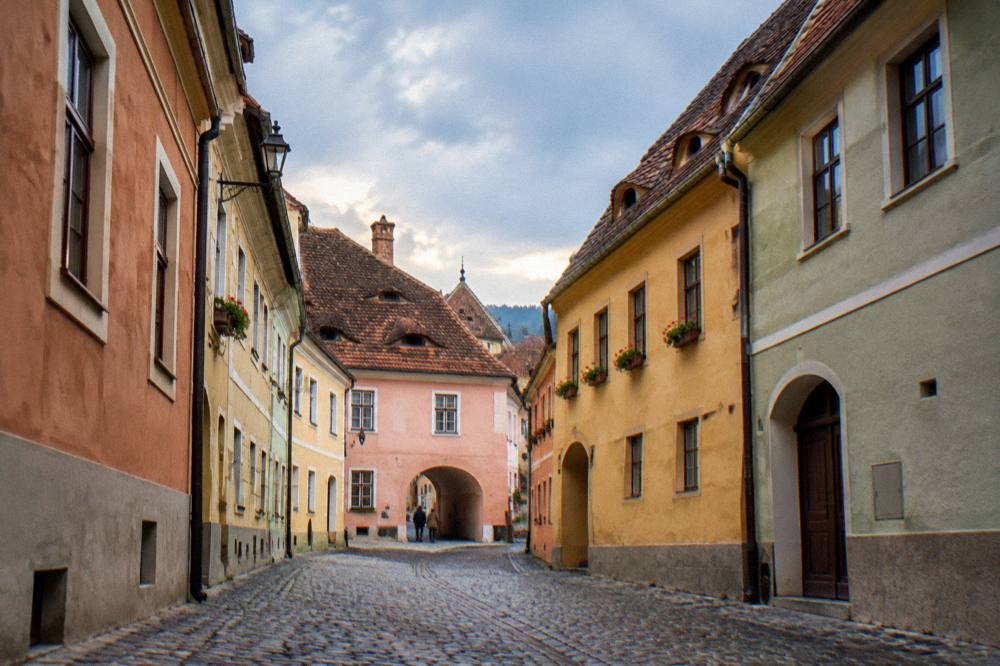 A narrow cobbled street in Sibiu old town with colourful house facades