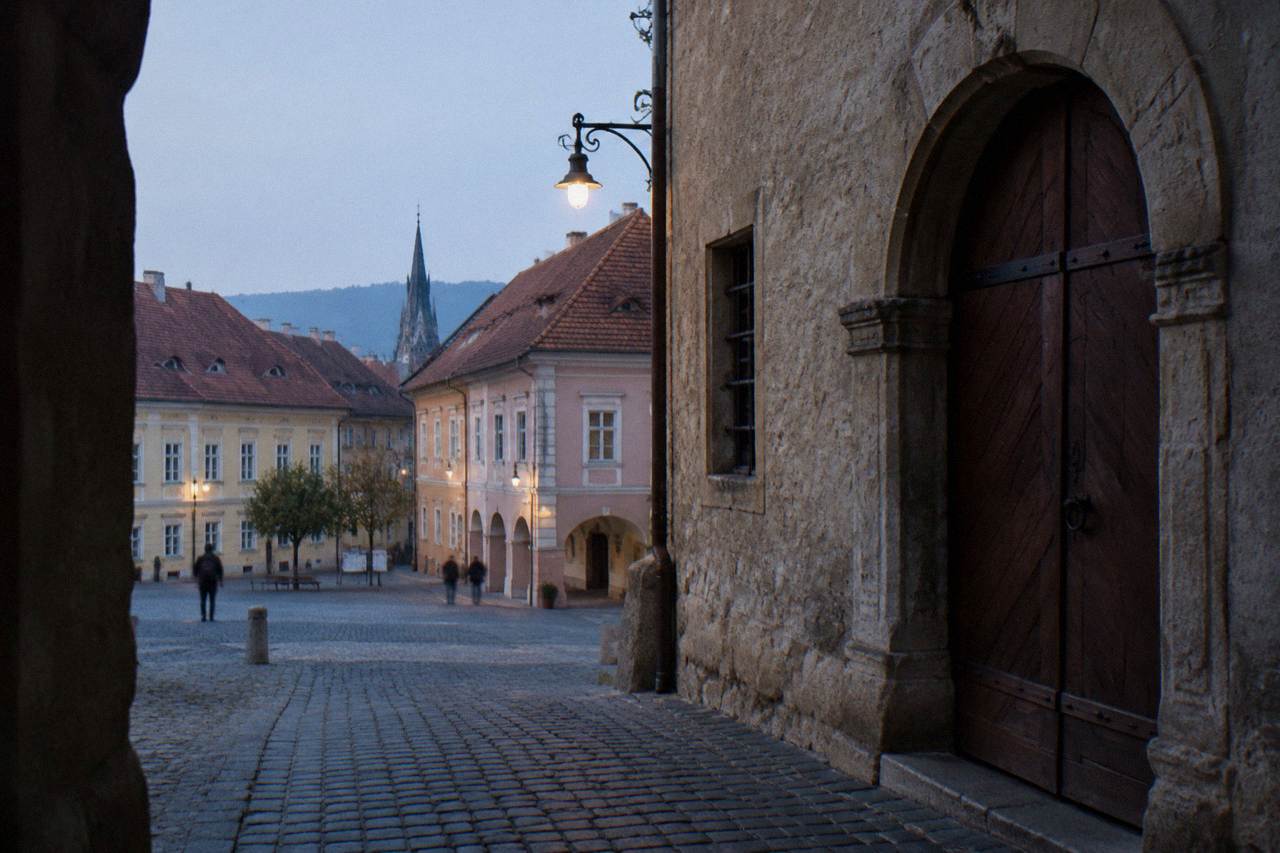 A closed museum entrance in the old town of Sibiu with a wooden door and stone wall