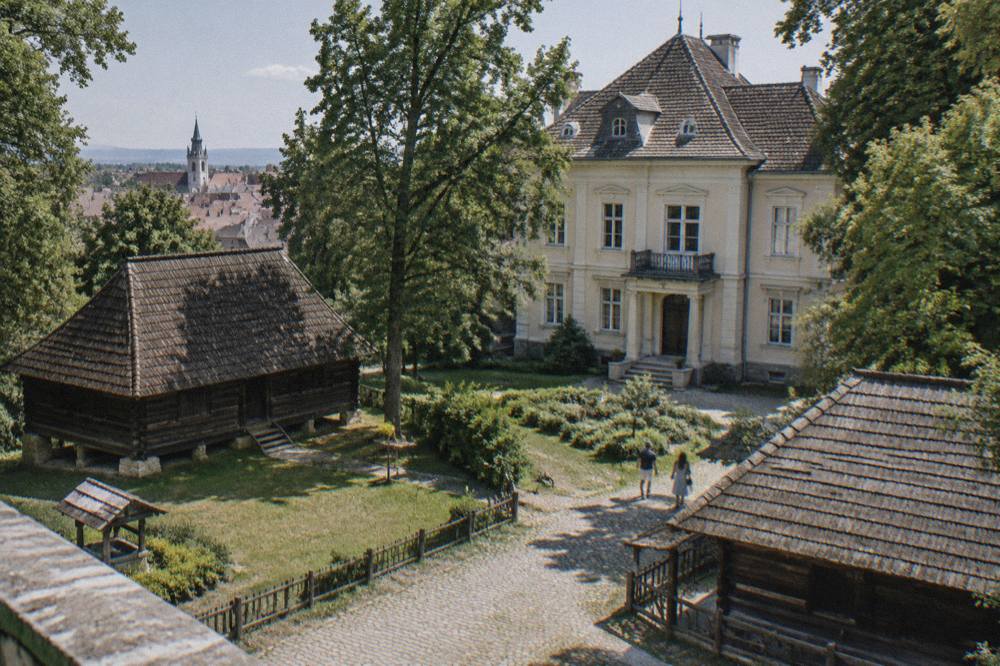 Traditional wooden farm buildings in a large open air museum among trees