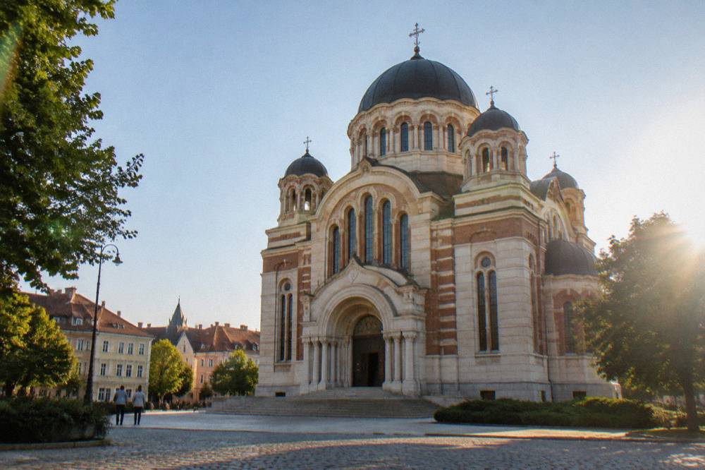 Facade and arched entrance of the Orthodox Cathedral under a clear sky in Sibiu