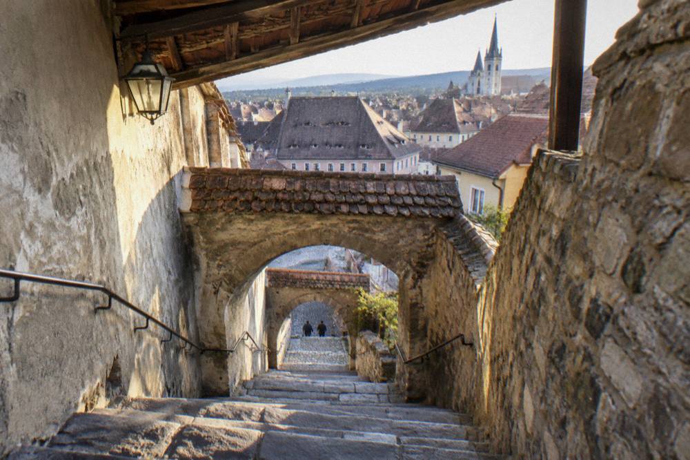 A view down the staircase toward Lower Town rooftops in late afternoon light
