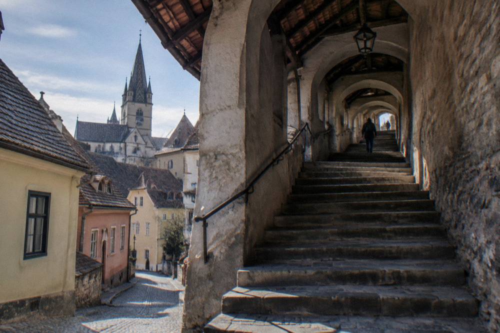 A quiet Lower Town street with small houses leading toward the base of the staircase