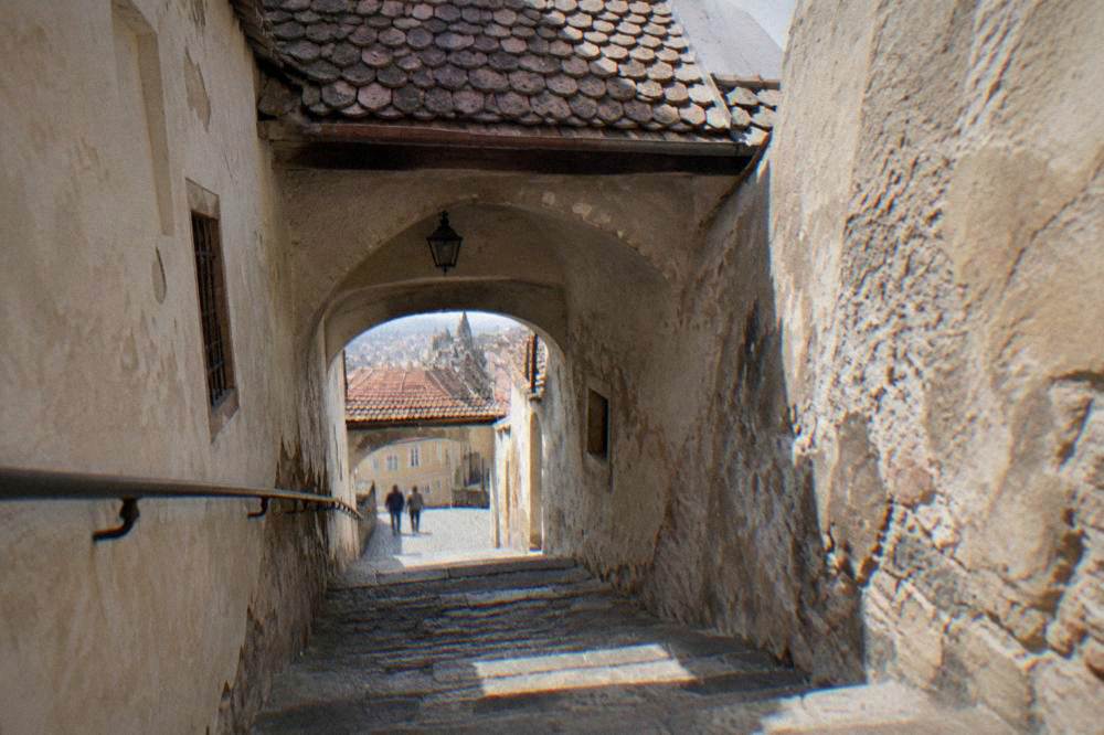 A narrow stone stairway runs down between old walls.