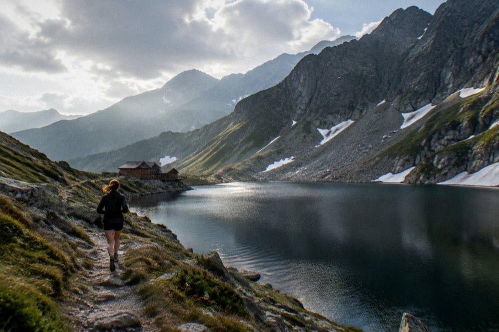A wide view of a mountain lake at the crest of a pass, early light on the water and ridgelines fading into haze