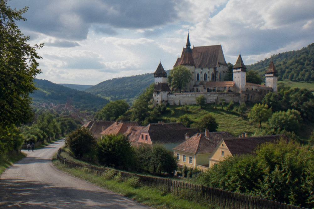 Country road winding between green hills toward a Transylvanian village