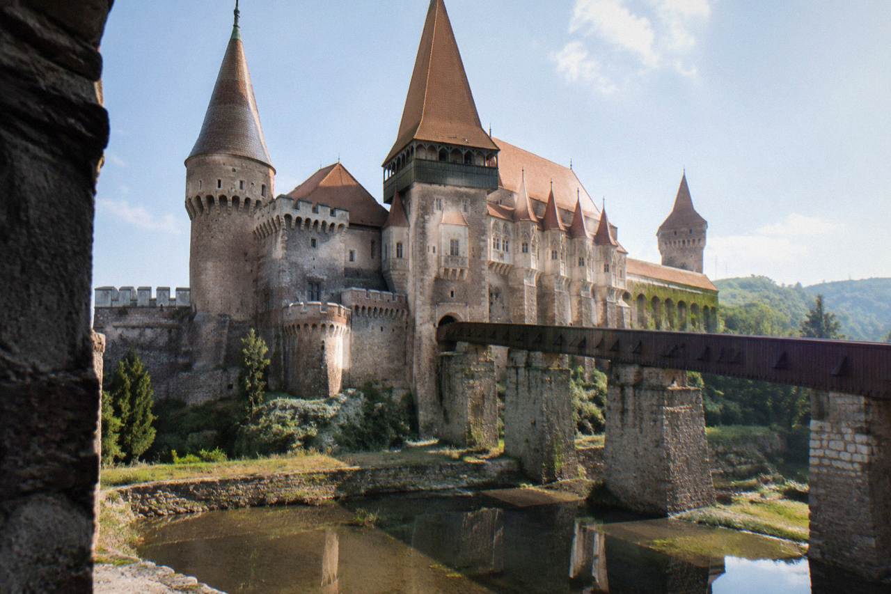 Corvin Castle at Hunedoara with its towers and bridge reflected at the water's edge