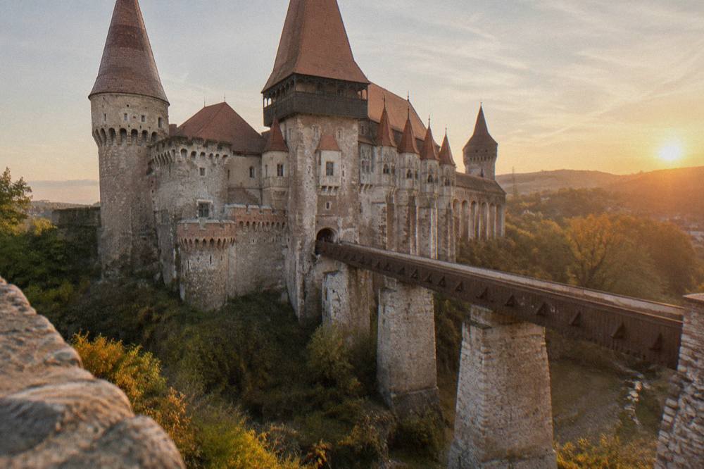 The long wooden bridge crossing the water moat to Corvin Castle's main gate