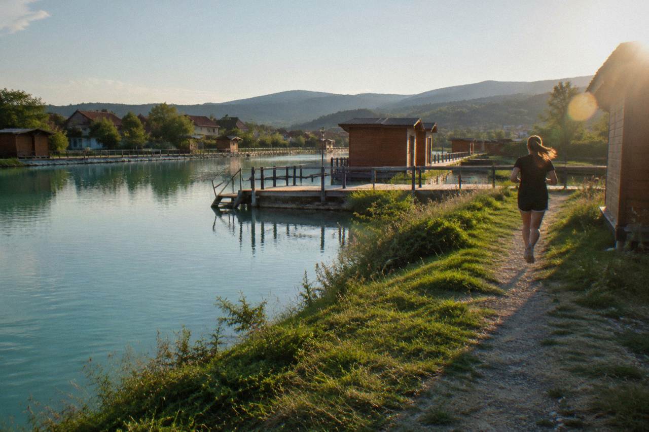Still turquoise salt lakes framed by grassy banks and wooden walkways on a calm day