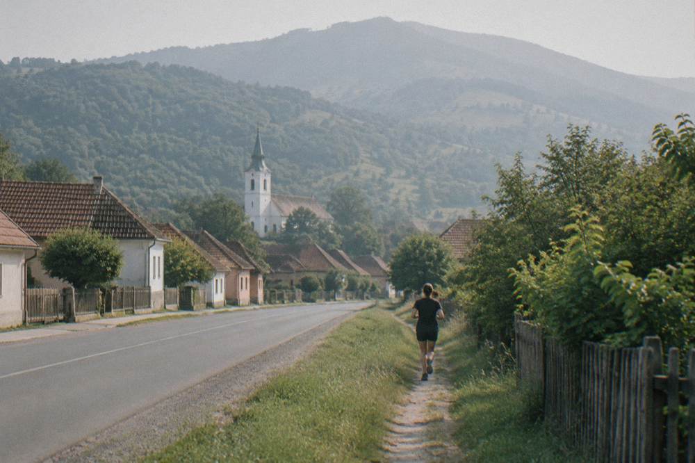 Footpath at the edge of Rășinari leading toward forested Cindrel foothills