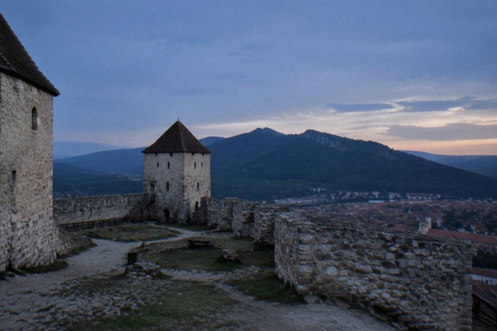 Stone fortress walls and a defensive tower seen from inside the citadel courtyard
