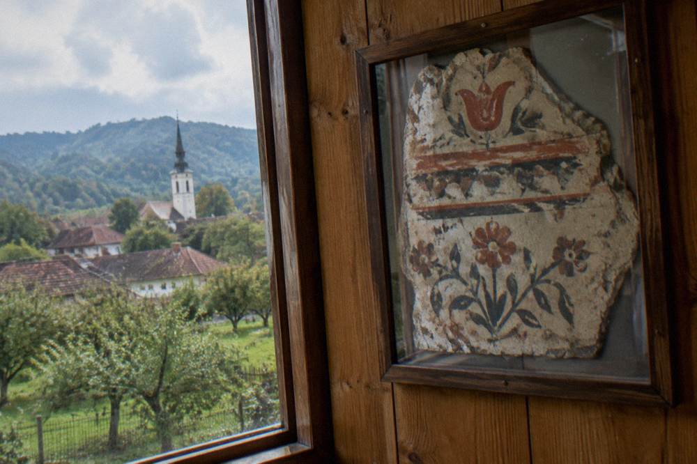 Painted folk icons on glass displayed on a wooden wall in a small village museum