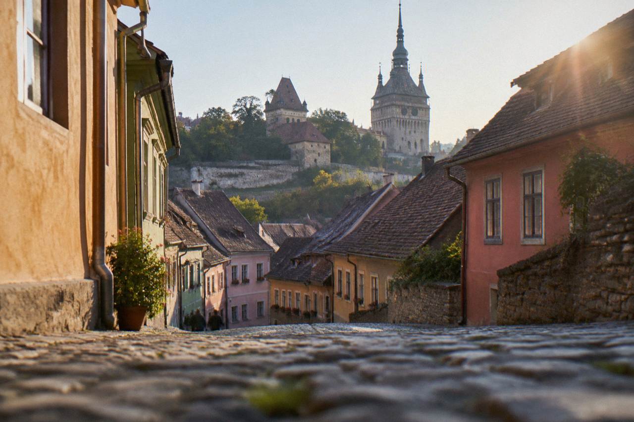 Colourful historic houses on a narrow cobbled street inside the Sighișoara citadel
