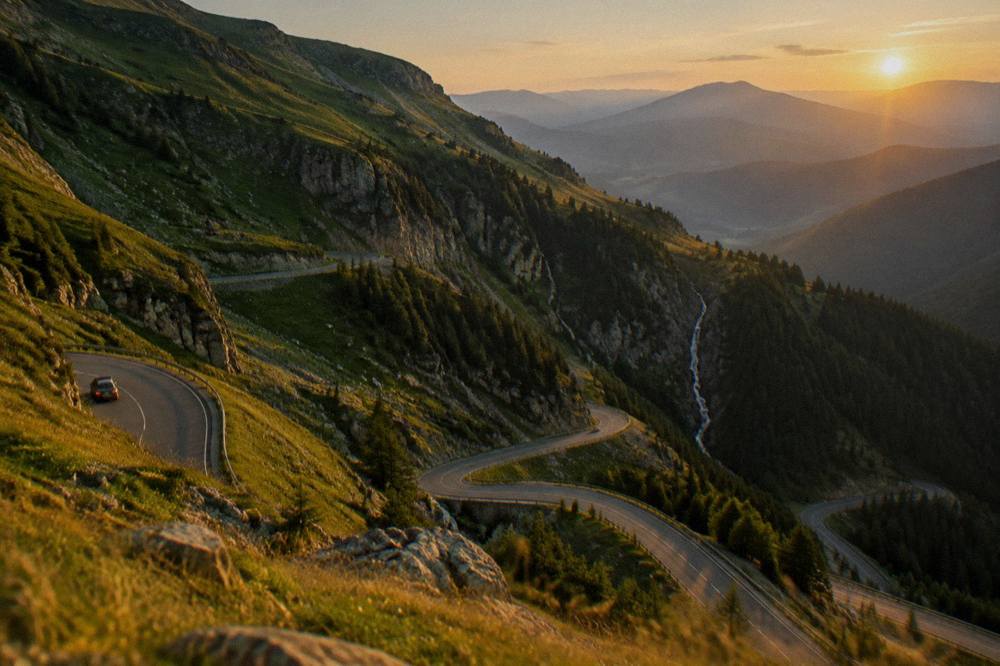Hairpin bends of a mountain road seen from above with forested slopes