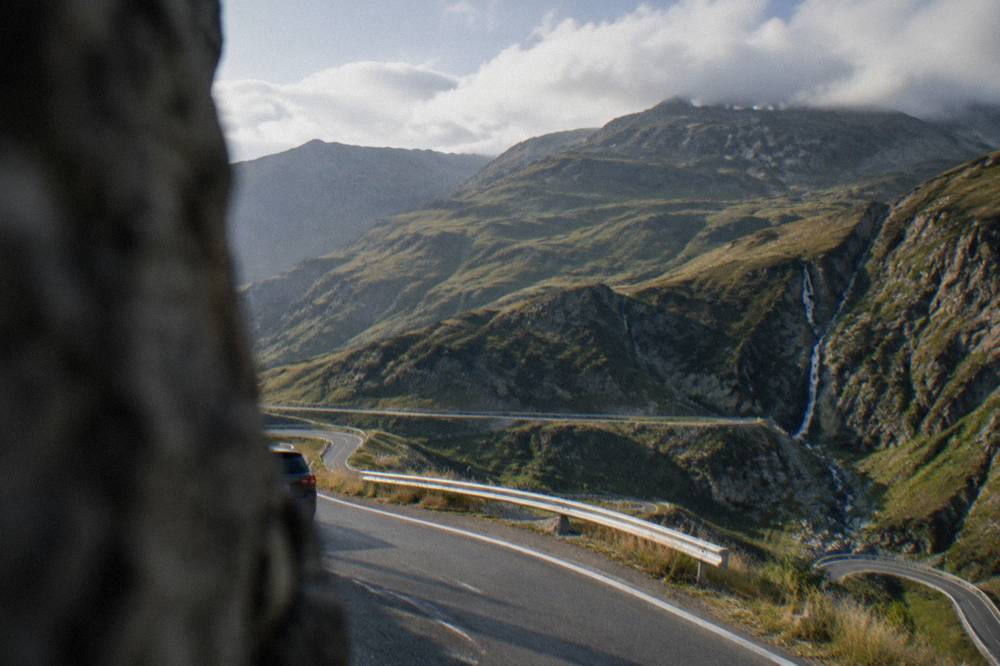 Clouds moving over a high mountain ridge above a road