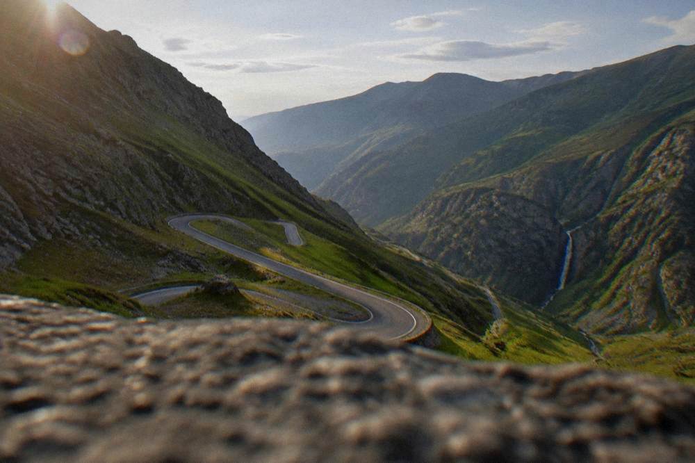 Hairpin bends of a mountain road curve high above a glacial lake