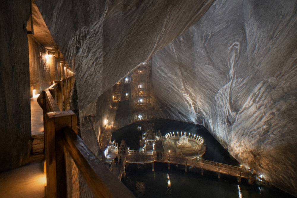 An underground salt gallery with wooden structures and soft amber lighting receding into the rock