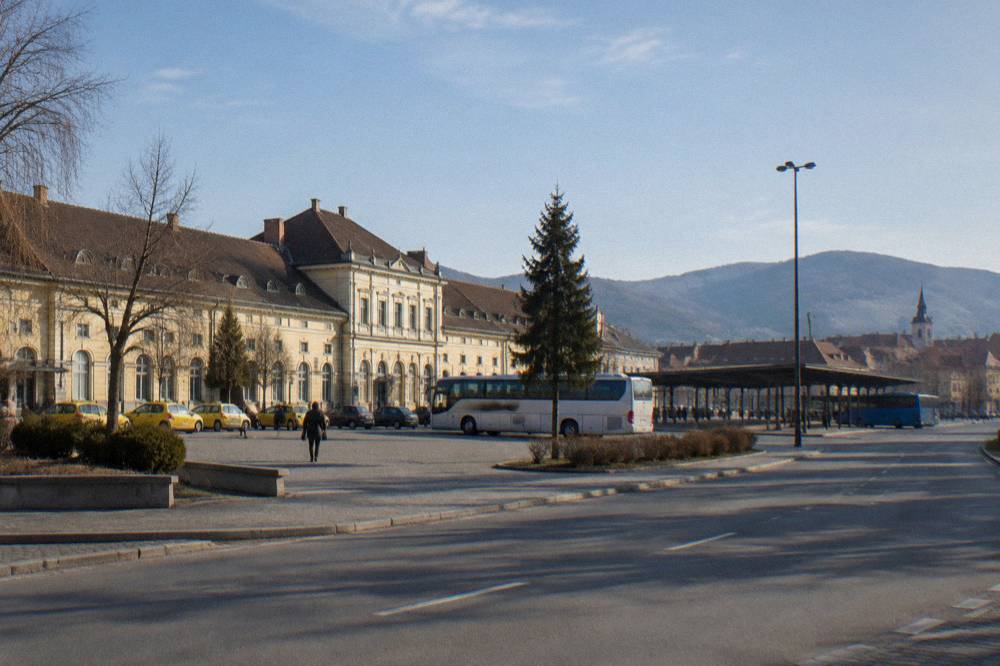An intercity coach on a Transylvanian road with hills in the background