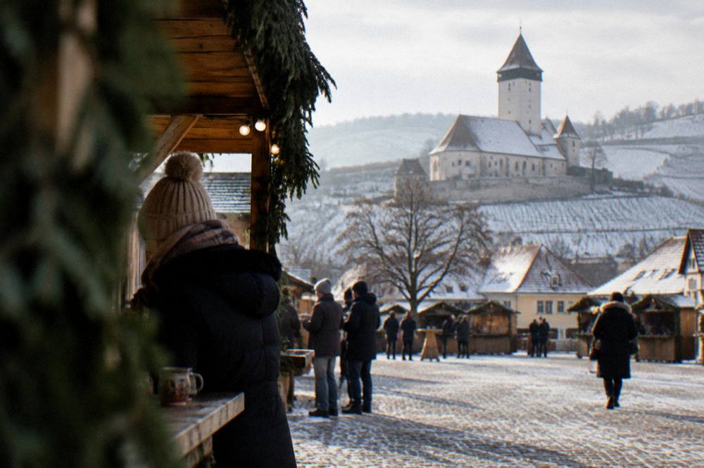 Mulled wine in ceramic cups at a wooden Christmas market stall in a square