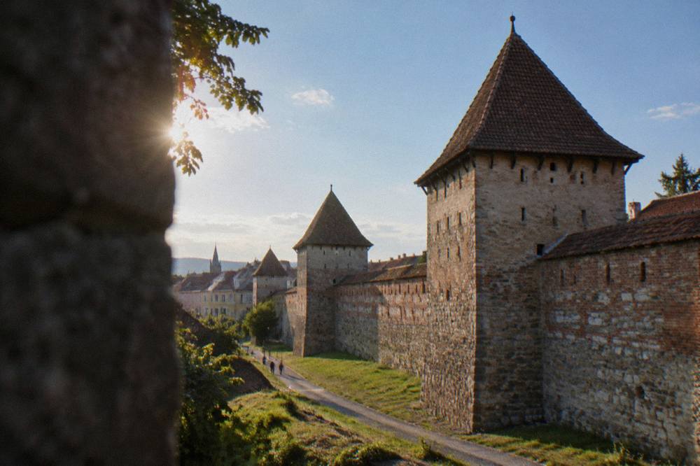 Medieval stone towers along the old city wall of Sibiu under a blue sky