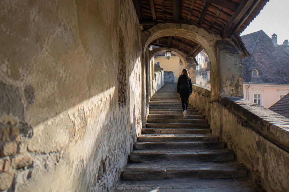 Stone steps of the Stairs Passage in Sibiu curving up between old walls toward the Upper Town