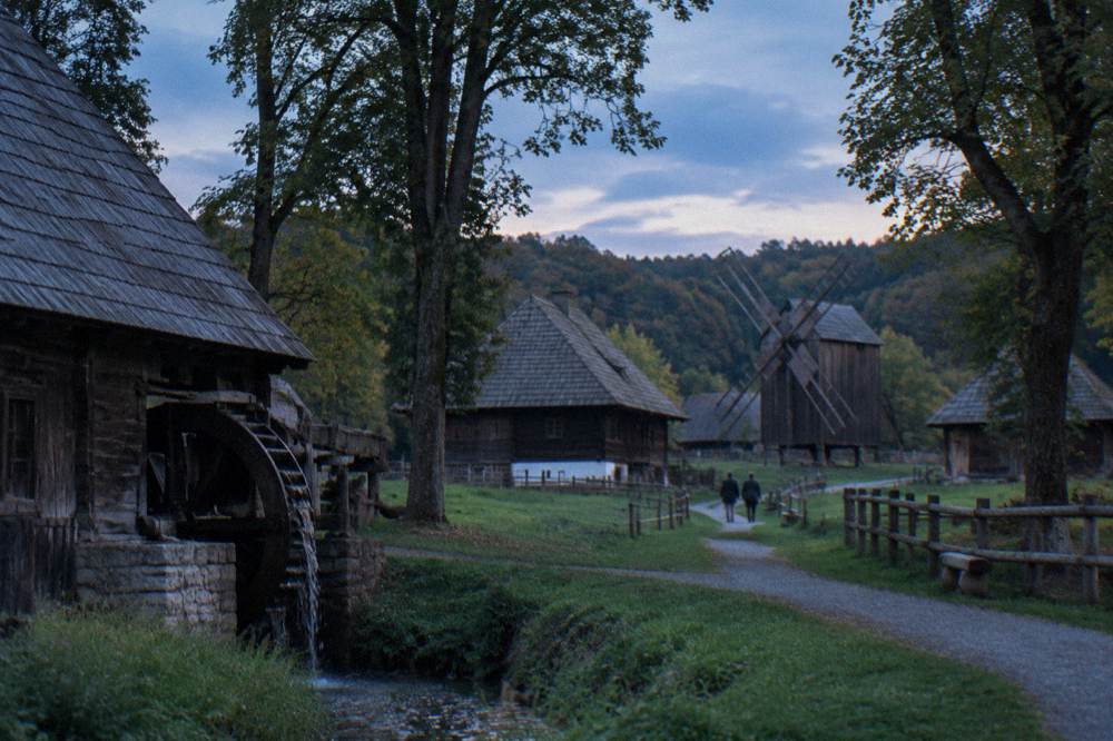 Traditional wooden farmhouses and barns of an open-air museum among trees