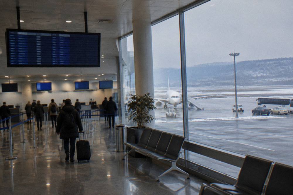 A departures board and check-in desks in a compact airport hall