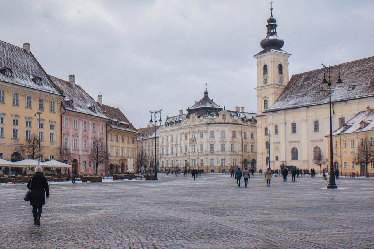 Colourful baroque houses and a church tower above the main square of Sibiu old town