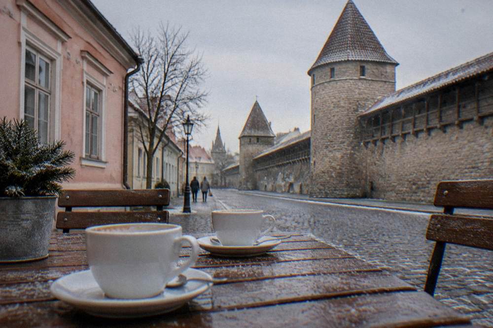 A pastry and a cup of coffee sit on a small cafe table.