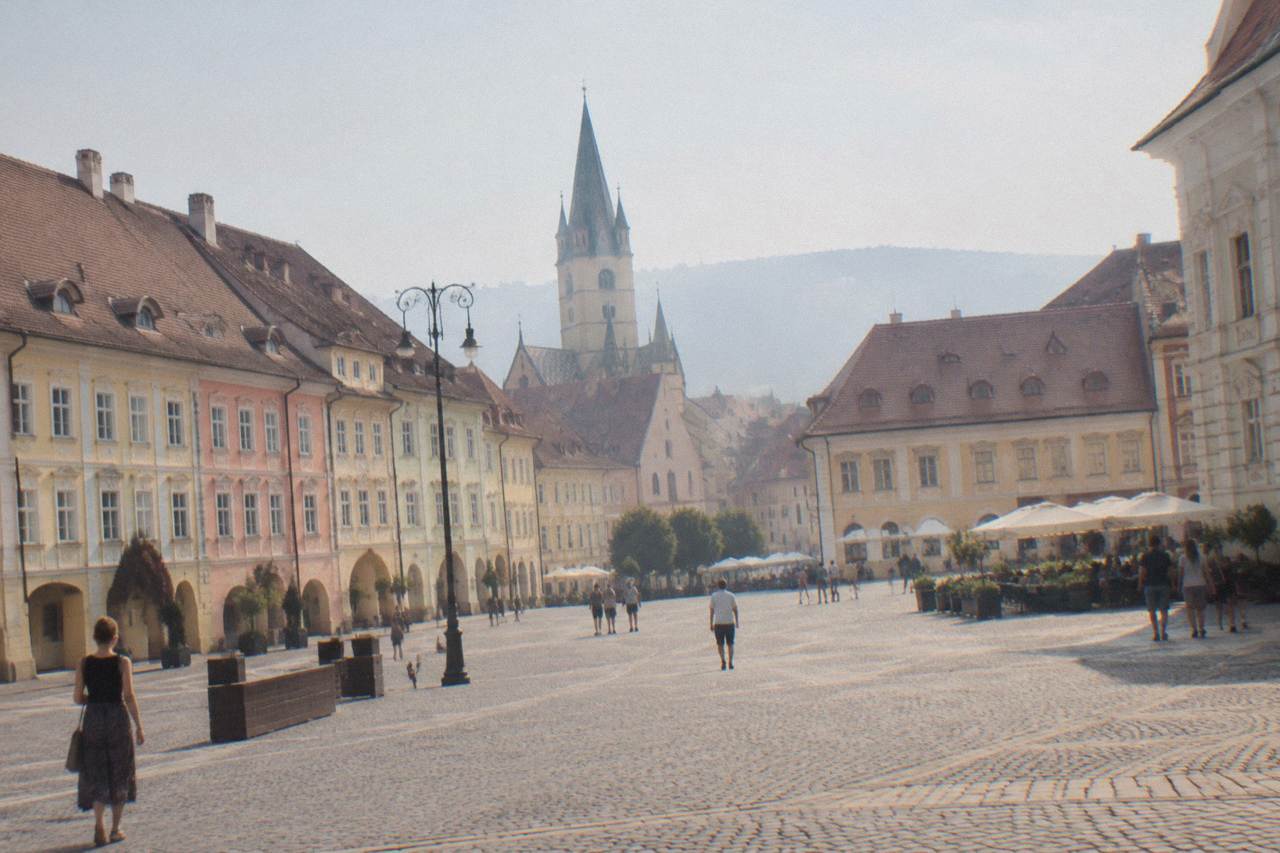 Colourful baroque and gothic buildings ranged around the wide open square of a Transylvanian old town