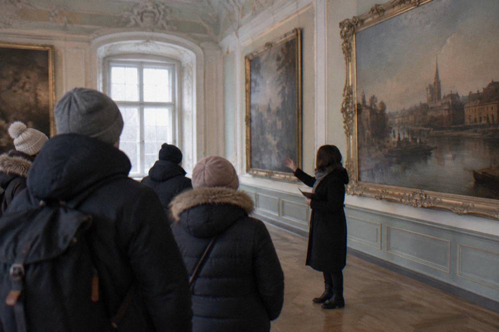 A guide showing a small group the painted galleries inside the Brukenthal Palace museum in Sibiu
