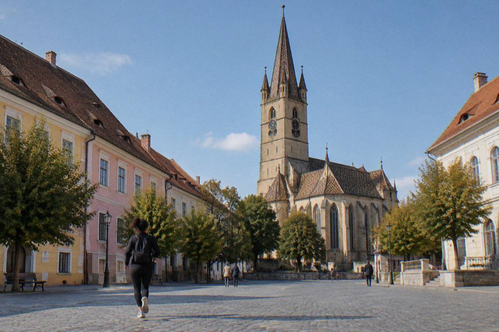 The Gothic tower of Sibiu's Evangelical Cathedral rising above the red roofs of the lower town