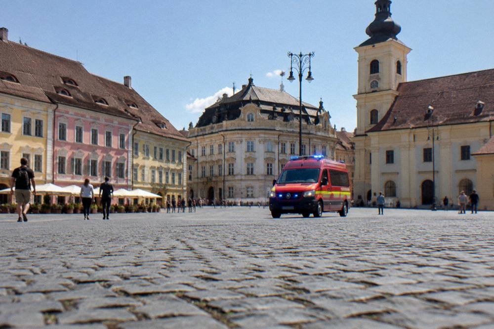 Emergency services vehicle with blue lights on a European city street