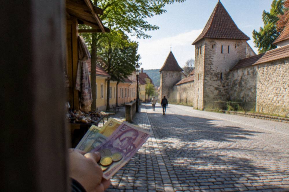 Romanian banknotes and coins held in a hand at a market stall