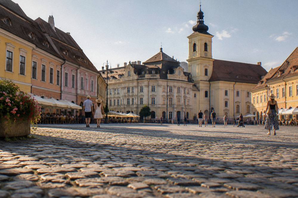A cobbled street of old houses with attic windows in a Transylvanian town at dusk