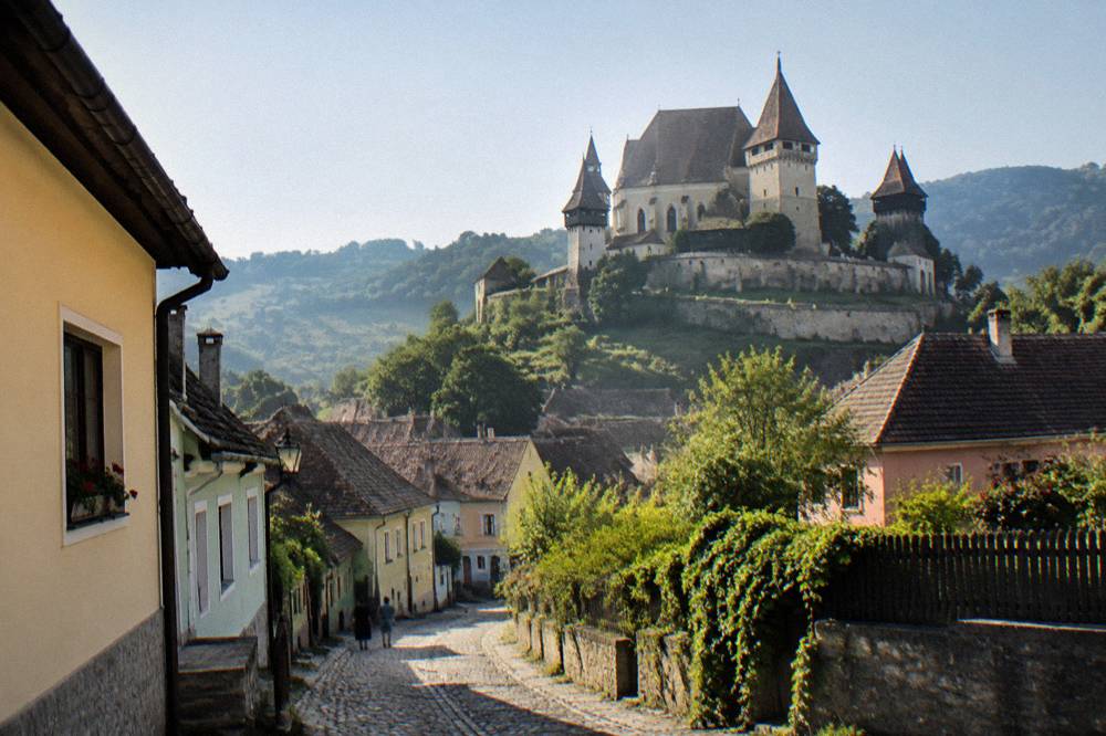 A fortified church tower above a small town street in Transylvania