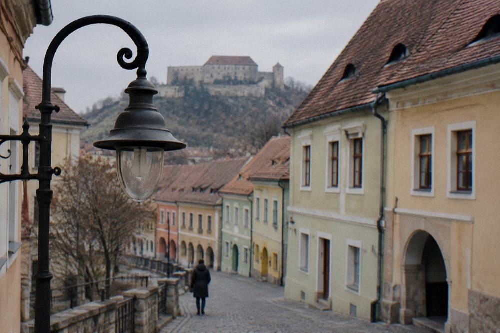 A stone fortress on a hill above a small Transylvanian town